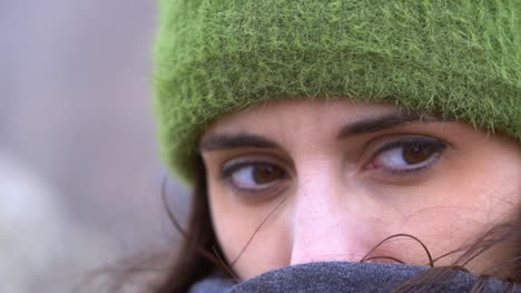 cute woman protecting herself from the wind on a winter cold morning at the mountain