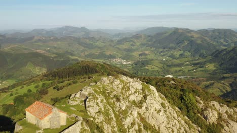 aerial drone view of the hermitage of santa eufemia on the top of a mountain in aulestia in the basque country