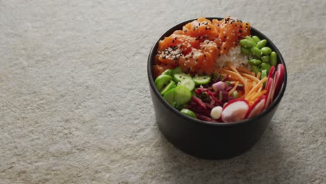 Composition-of-bowl-of-rice,-salmon-and-vegetables-on-white-background