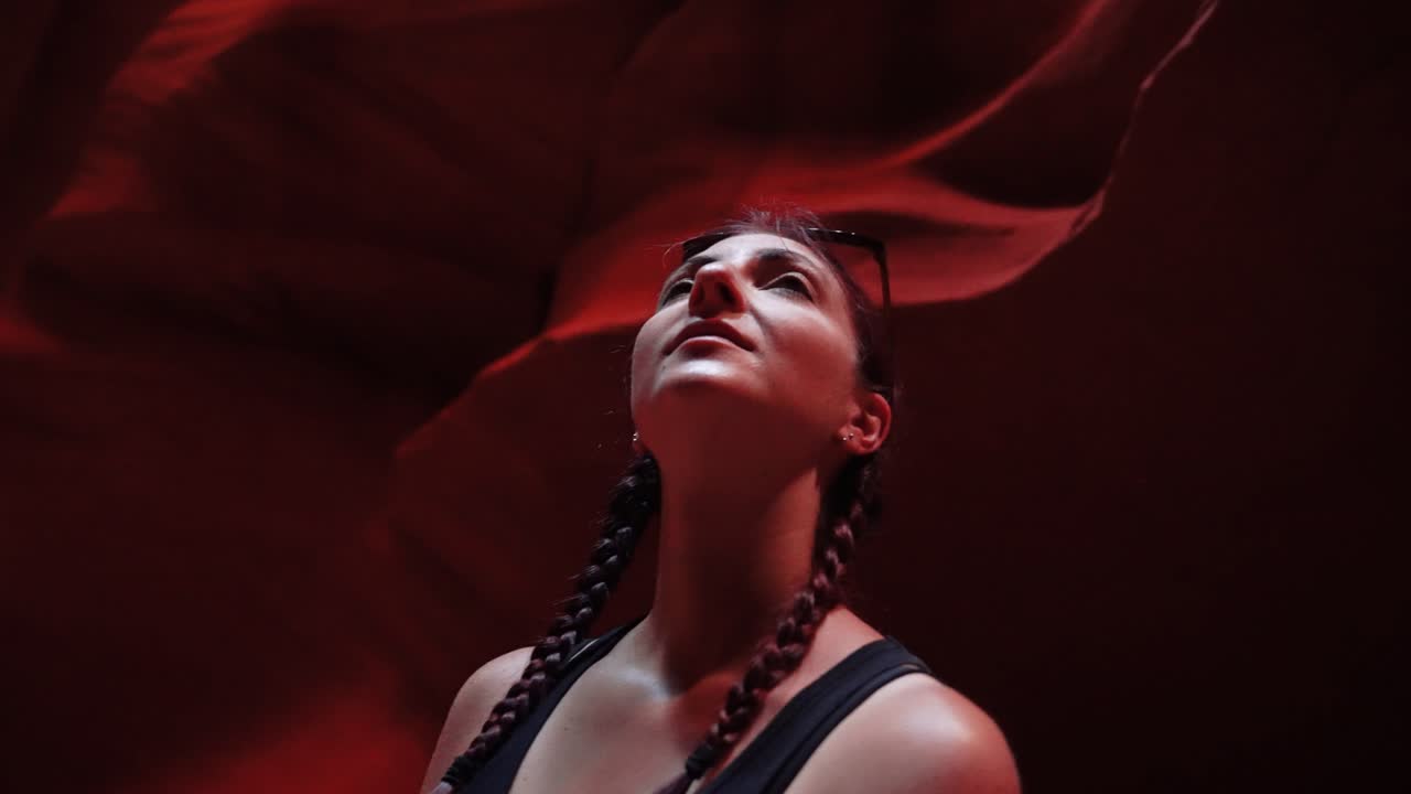 A woman watch the Antelope Canyon in Arizona, with its wind and water-carved rock walls, creates enchanting and suggestive shapes.Shot in 4K with Sony A7S III