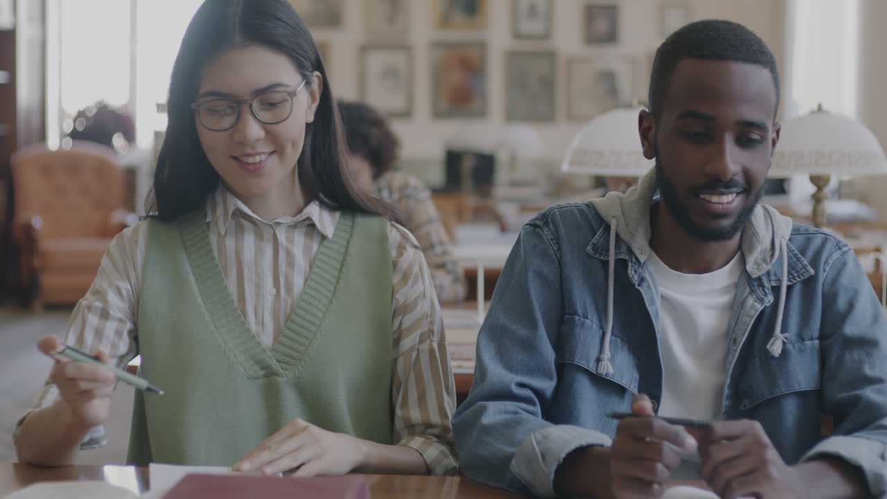 dos estudiantes estudiando en una biblioteca