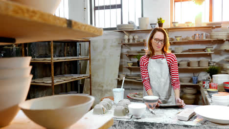 portrait of female potter using digital tablet 4k