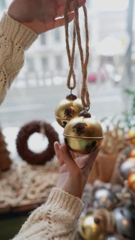 hands holding christmas bells and ornaments, festive display