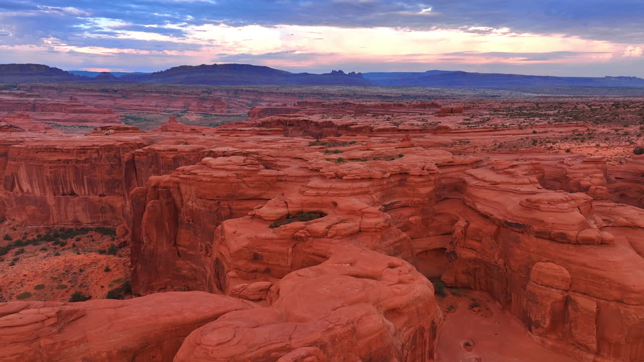 Sorvolo dei canyon rossi, arrotondati e scoscesi nel vasto deserto. Filmato aereo con drone sopra le splendide rocce nell'Arches National Park, Utah, USA