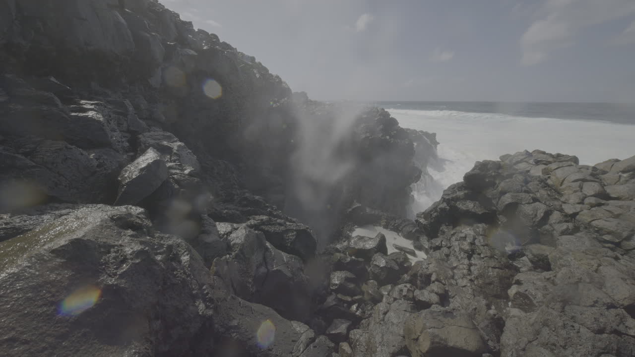 fuertes olas chocando contra las rocas volcánicas