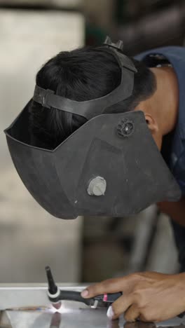 person welding with a helmet and torch