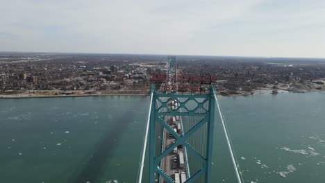 ambassador bridge sign and endless line of semi-trucks piling on it, aerial view