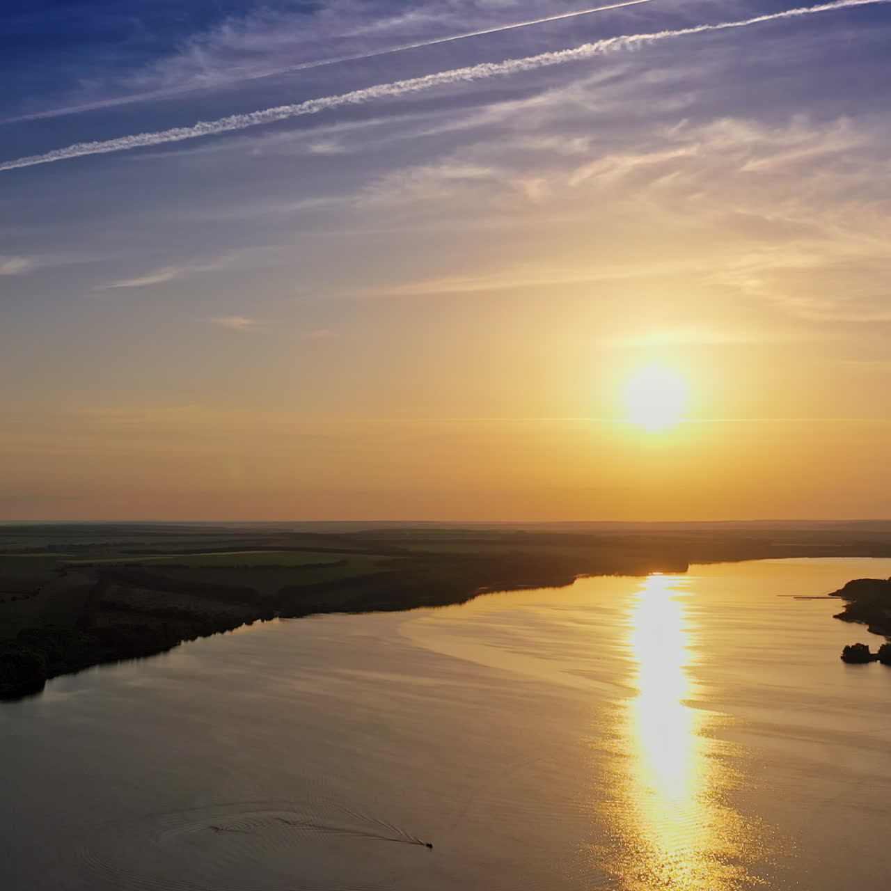 Golden path over water surface at sunset. Beautiful view on the natural landscape with evening sun that reflects in water. Aerial view.