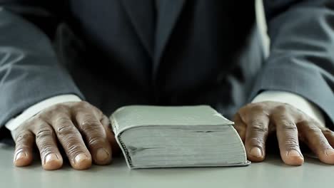 black man praying to god with bible in hands caribbean man praying with background with people stock video stock footage