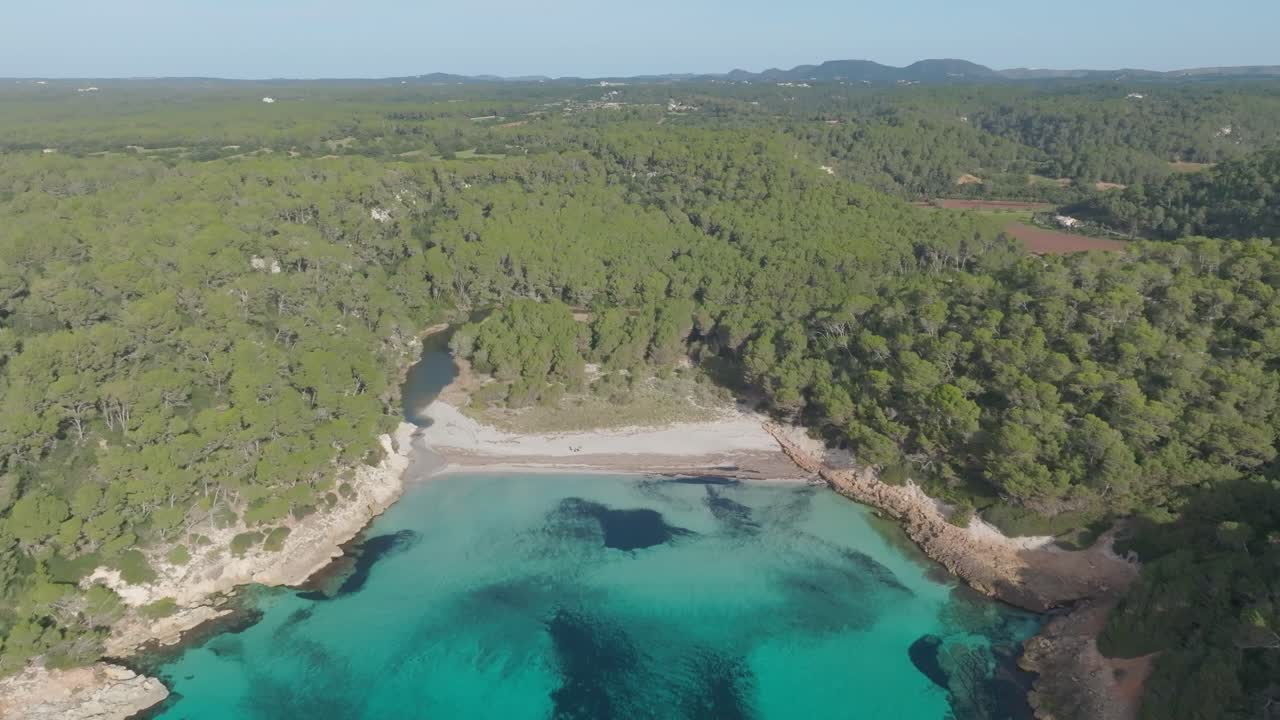 paisaje natural boscoso, cala media playa de menorca arena blanca mar azul toma aérea de un avión no tripulado