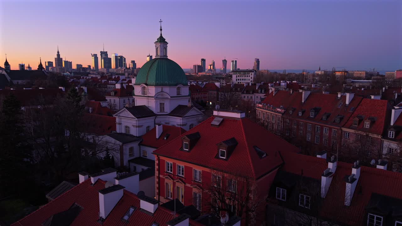 amanecer sobre varsovia, polonia, toma de avión no tripulado de la iglesia católica de san casimiro, techo rojo de los edificios y horizonte del centro de la ciudad