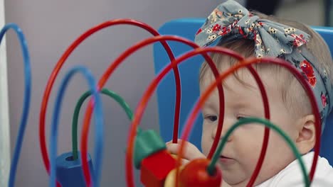 child plays with a multi-colored toy 24