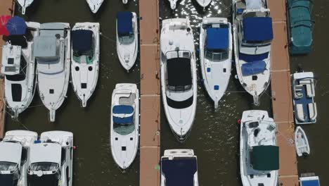 top down view private boats docked in rows along floating docks at local marina