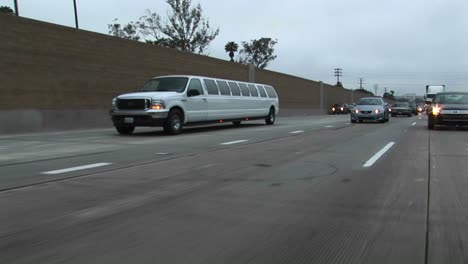 a stretch limo drives down a freeway