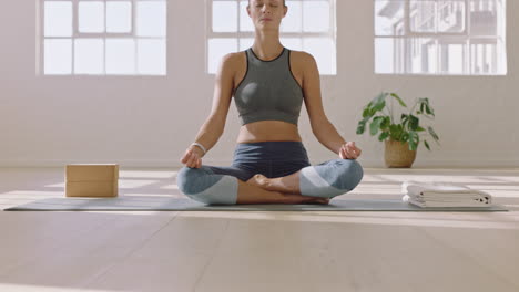 attractive yoga woman practicing lotus pose meditation enjoying healthy spiritual lifestyle training mindfulness exercise in studio at sunrise