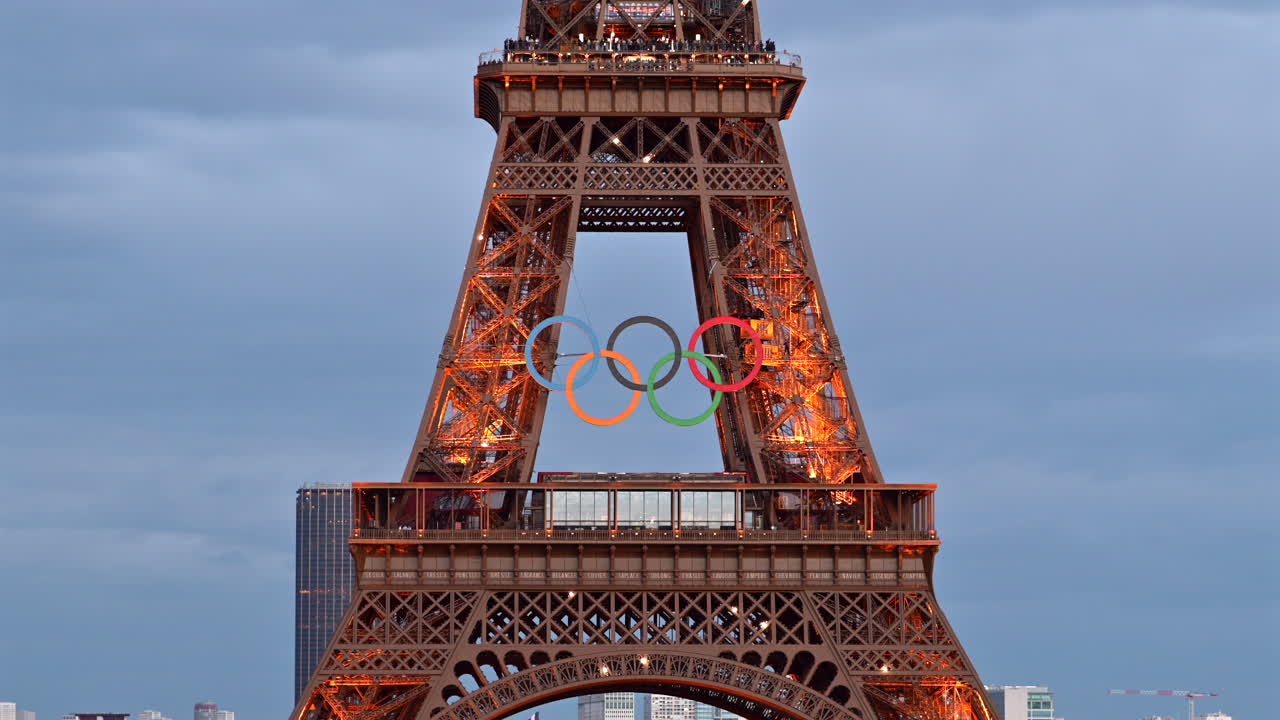The Eiffel Tower with the Olympic Games sign sparkling in the evening in Paris, France