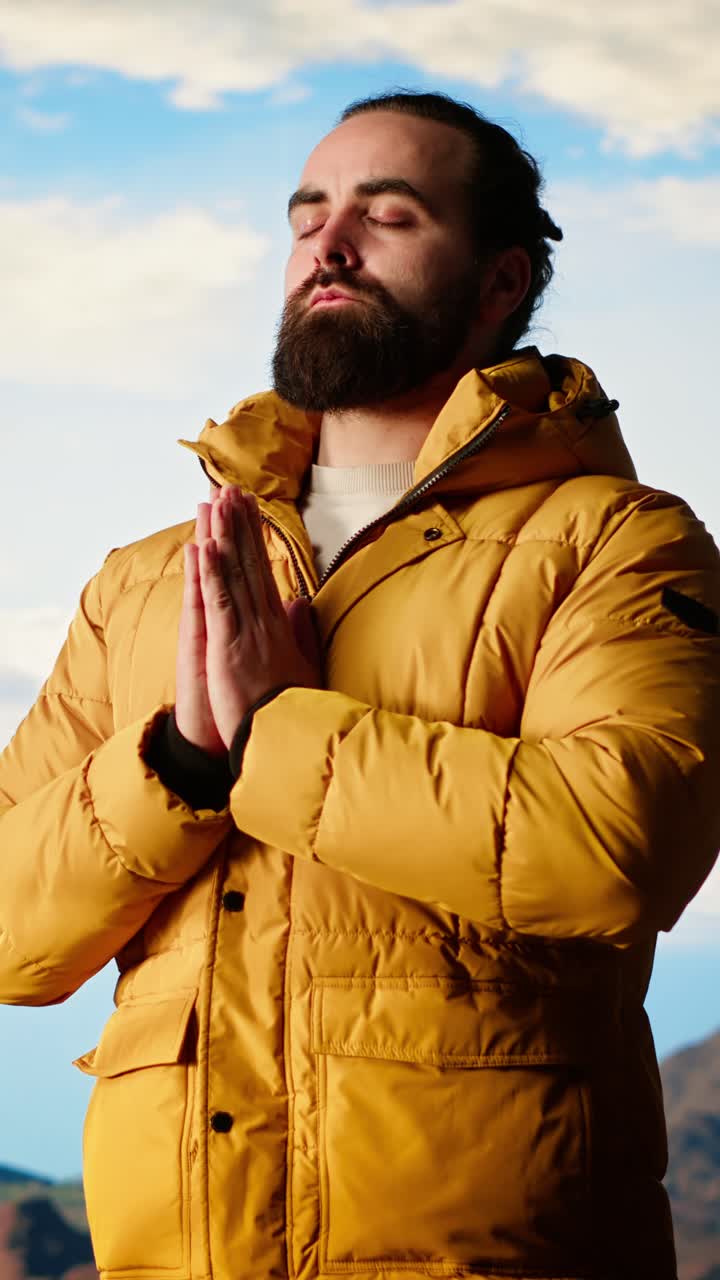 Bearded Man Meditating Outdoors with Prayer Hands Against Blue Sky