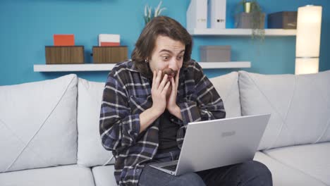 el hombre que mira la computadora portátil está sorprendido y feliz.
