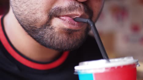 Man drinking soda through a straw