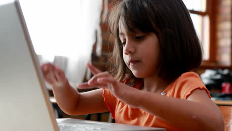 una niña pequeña usando una computadora portátil en el aula