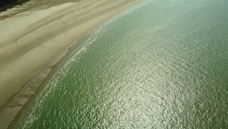 aerial view of a sandy beach and turquoise ocean