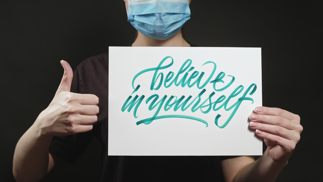 자신을 믿으십시오 여성 마스크는 엄지손가락을 지지합니다.