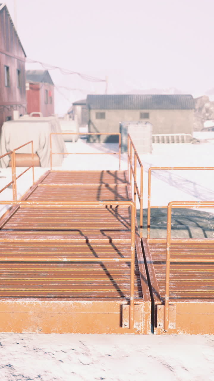 Bright orange bridge connecting buildings in snowy remote location