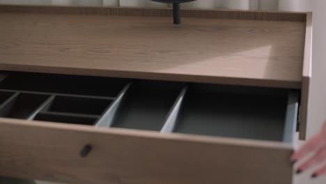 a close-up of a wooden cosmetic organizer drawer, revealing neat compartments for beauty products