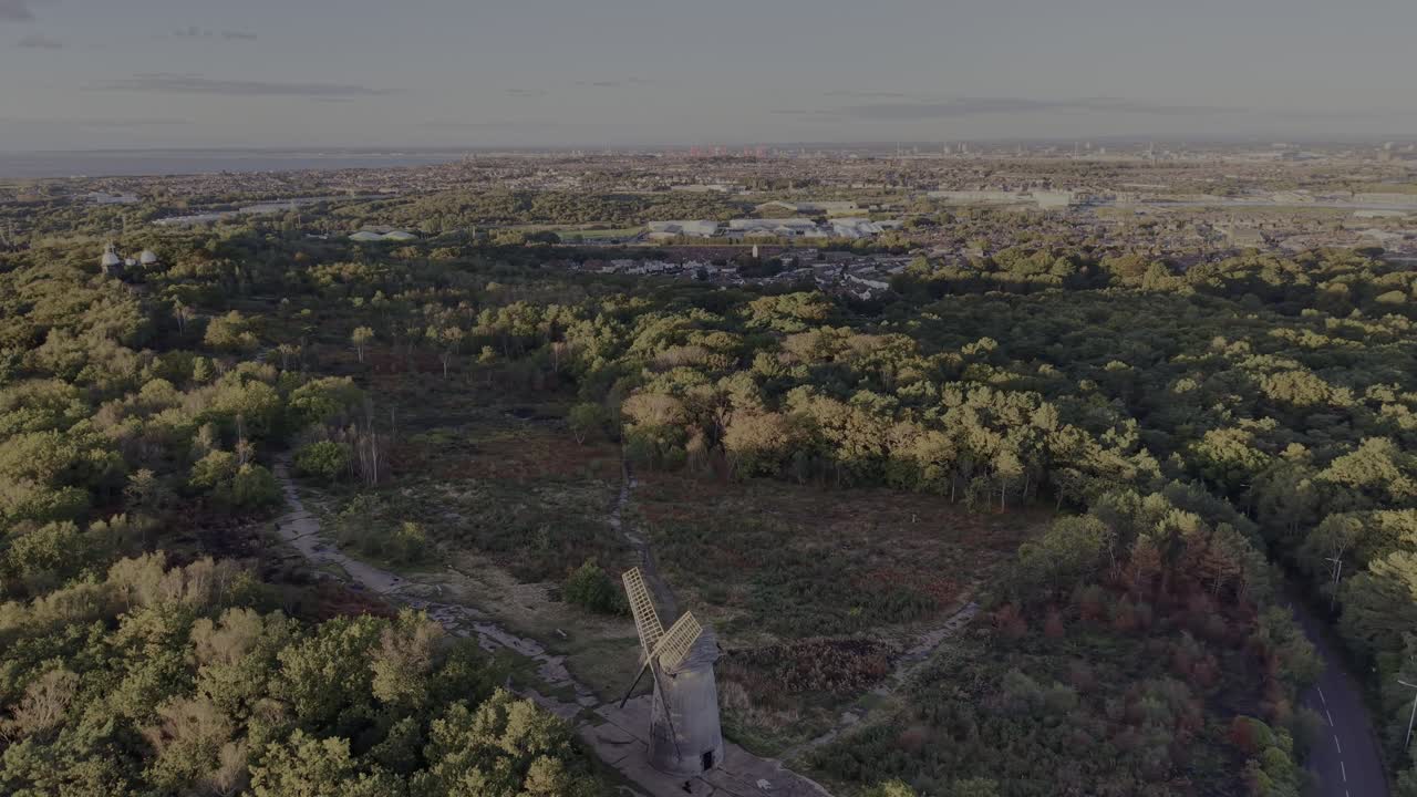 Stunning Bidston Hill and Windmill, slow clockwise drone rotate, revealing beautiful sunlit Liverpool cityscape, Wirral, UK