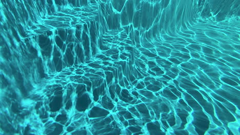 underwater slow motion of light reflecting off of the floor of a swimming pool