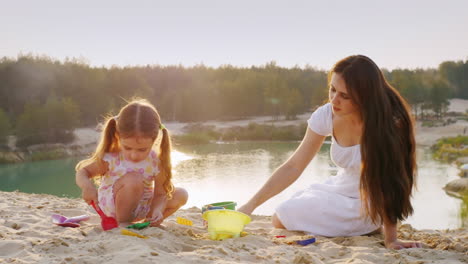 Mama-Und-Tochter-Spielen-Im-Sand-Geformte-Figuren-Aus-Sand-Glückliche-Kindheit