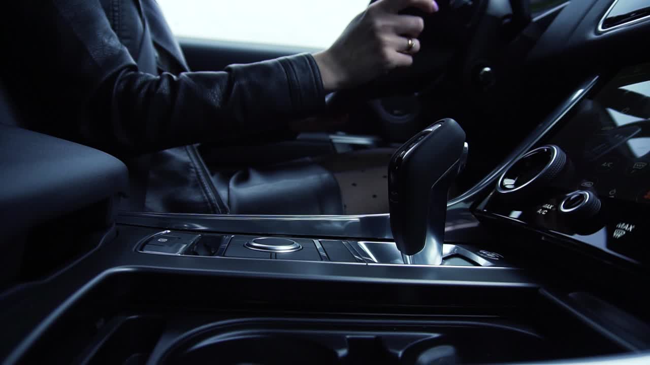 женщина, управляющая роскошной машиной.