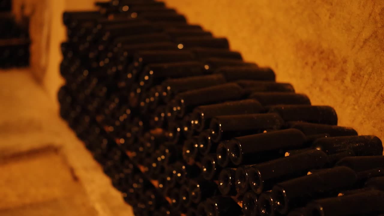 Bottiglie di vino impilate in una cantina in penombra