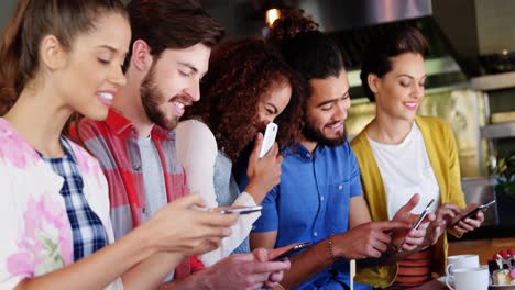 Grupo-De-Amigos-Interactuando-Entre-Sí-Y-Usando-Teléfonos-Móviles