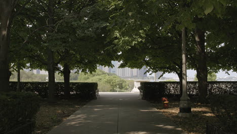 push down tree lined walkway in park towards lake michigan and chicago city skyline