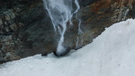 flying over waterfall stream flowing at fellaria glacier in valmalenco of valtellina, italy