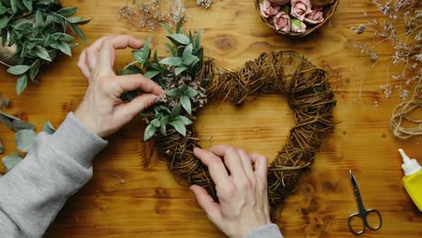 hands decorating spring floral wreath.