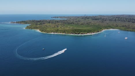 Boat-pulls-tourists-on-spinning-raft-at-idyllic-Playa-Estrella,-Panama