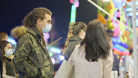 people at a nighttime festival wearing masks