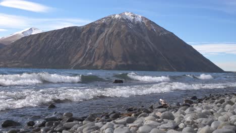 beach and shoreline of lake ohau with mountain ranges in new zealand - wide shot