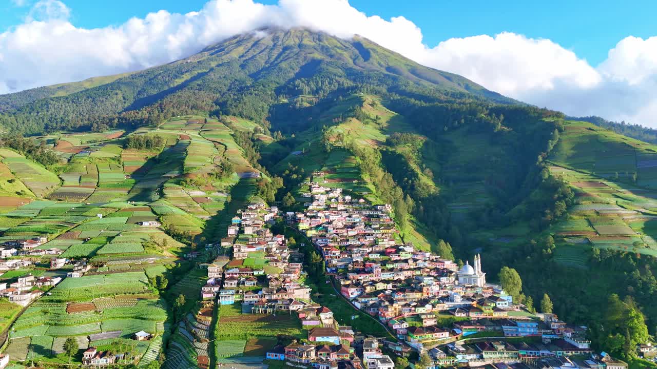 Drone shot capturing a traditional hillside village with colorful houses and surrounding vegetable plantations in the highlands. Nepal Van Java Village, Mount Sumbing, Indonesia