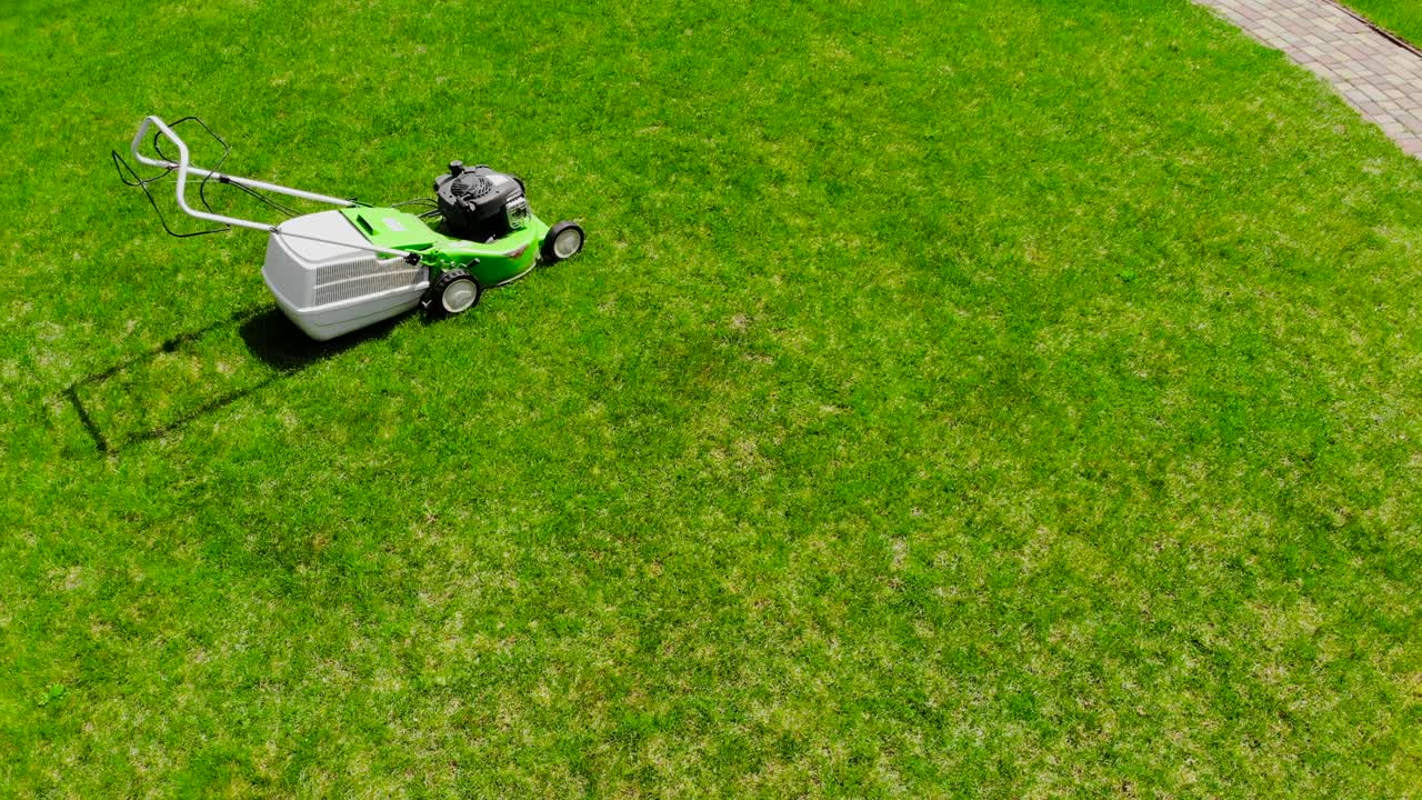 야드에서 신선한 잔디의 원에 녹색 잔디 기기의 드론 시각. 잔디를 자르는 도구.