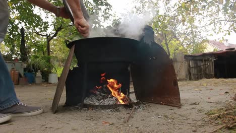 el hombre revisa la olla mientras cocina estofado de pescado