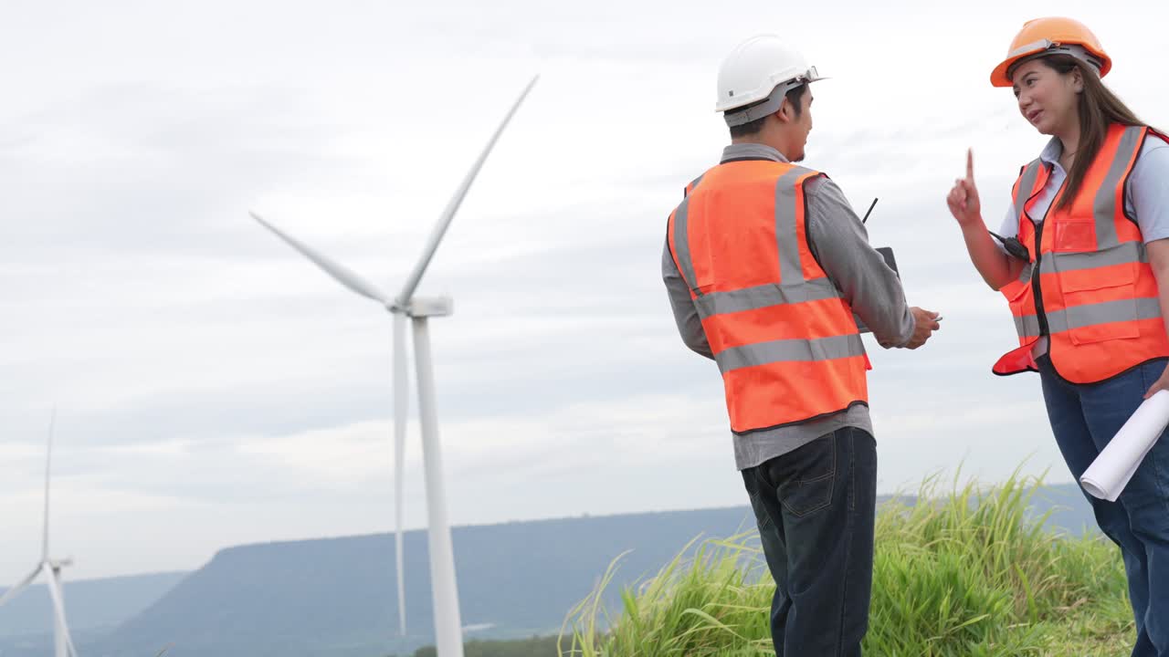 Progressive concept of engineers working in the wind farm atop of the mountain.
