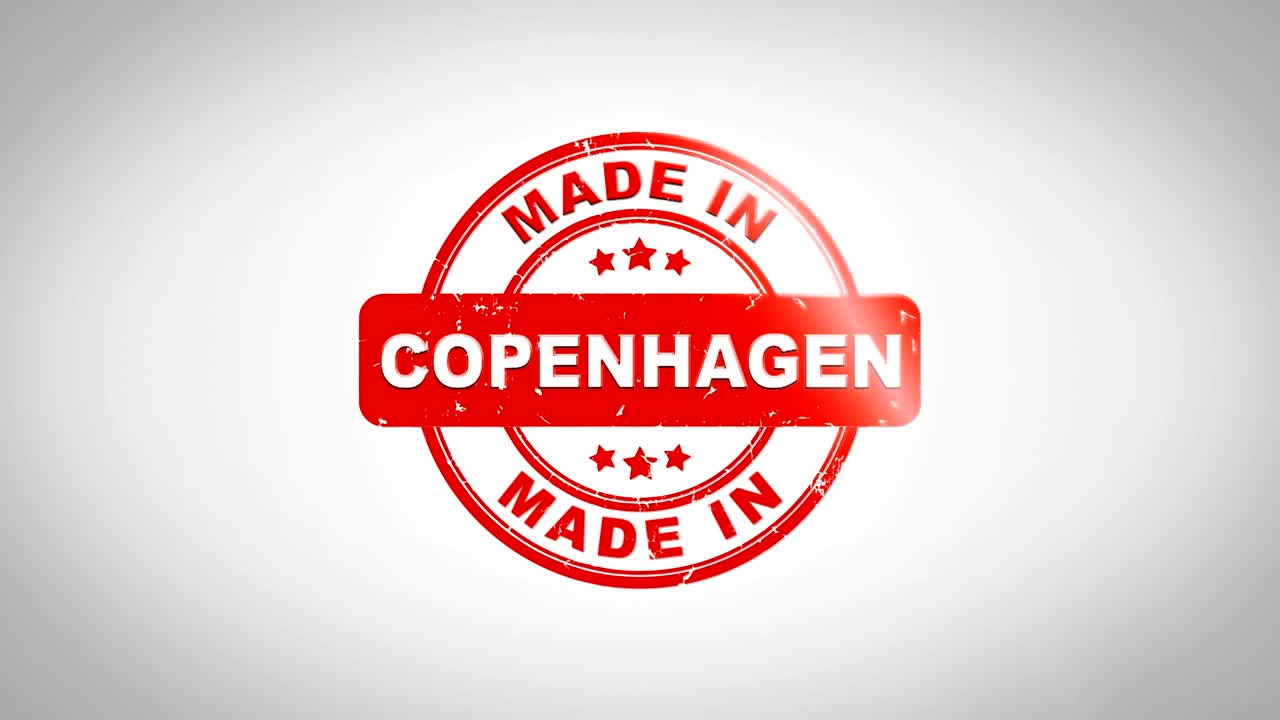 сделанный в копенгагене подписанный штамповый текст деревянная анимация марки. красная чернила на чистом белом бумажном фоне с зеленым матовым фоном.