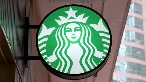 the starbucks logo, representing the iconic american coffee chain, is prominently showcased outside its hong kong location.