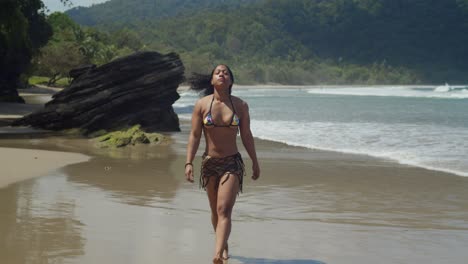 Picture-a-determined-girl-in-a-bikini,-walking-her-toned-body-amidst-the-beauty-of-an-incredible-tropical-beach