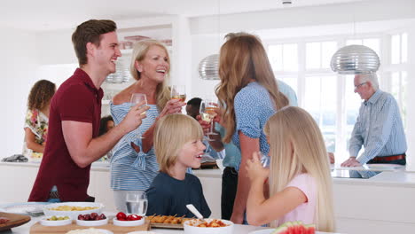 Toma-A-Cámara-Lenta-De-Familiares-Y-Amigos-De-Varias-Generaciones-Reunidos-En-La-Cocina-Para-La-Fiesta-De-Celebración