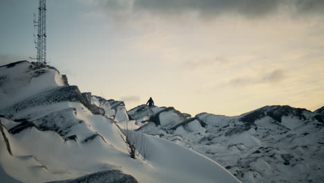 Toma-Estática-De-Un-Excursionista-Navegando-Por-El-Peligroso-Terreno-Nevado-En-La-Cima-De-Lovstakken