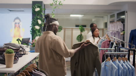 Una-Mujer-Ayuda-A-Un-Hombre-A-Elegir-Una-Chaqueta-En-Un-Centro-Comercial